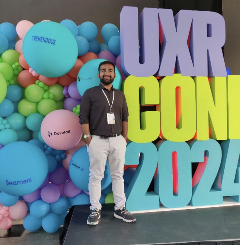 Kshitij Chhabra in front of UXR Conference sign