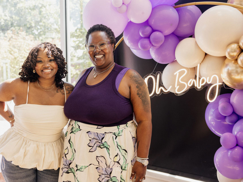 Leslie Coney and Jazmin Williams in front of backdrop of purple and gold balloons