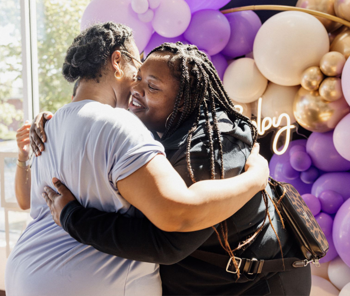 two people hugging at the baby shower