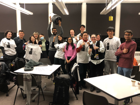 Group photo of Björling and students in the class, some wearing robot t-shirts and some holding robots