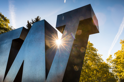 Bronze W statue on UW campus with sunbeam shining through gap